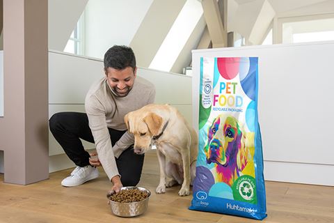 Person feeding a Labrador dog